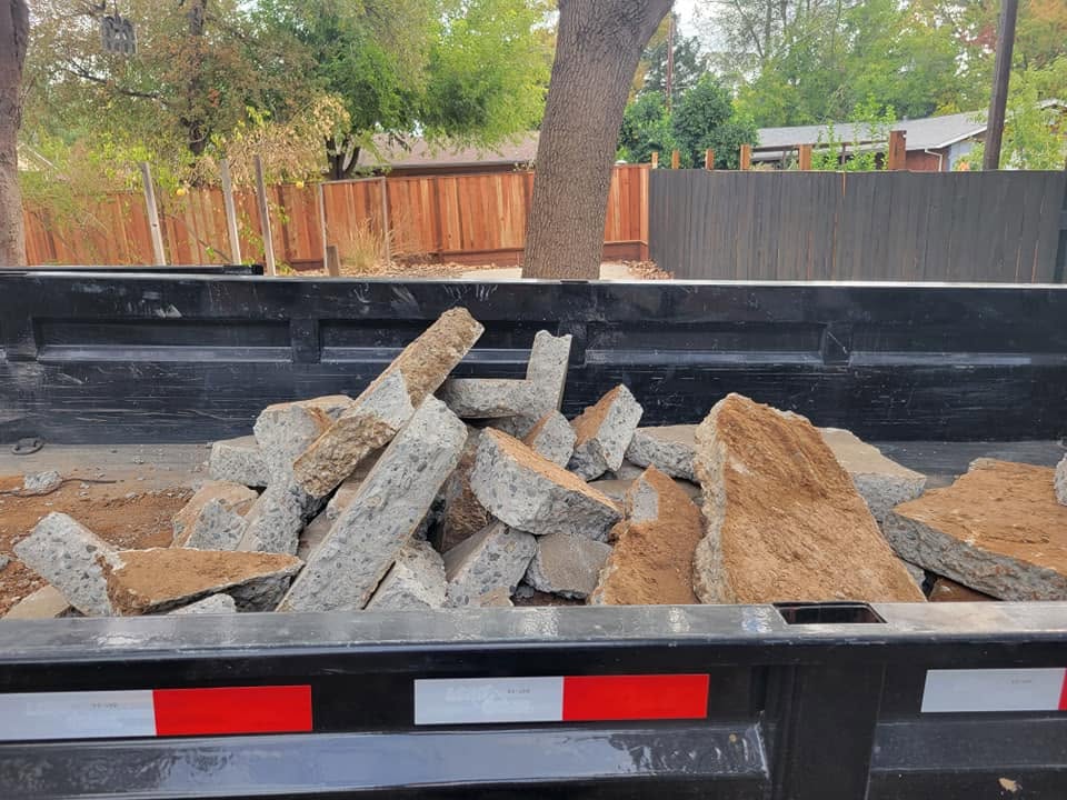 Dump trailer loaded with broken concrete and demolition debris from a residential removal job